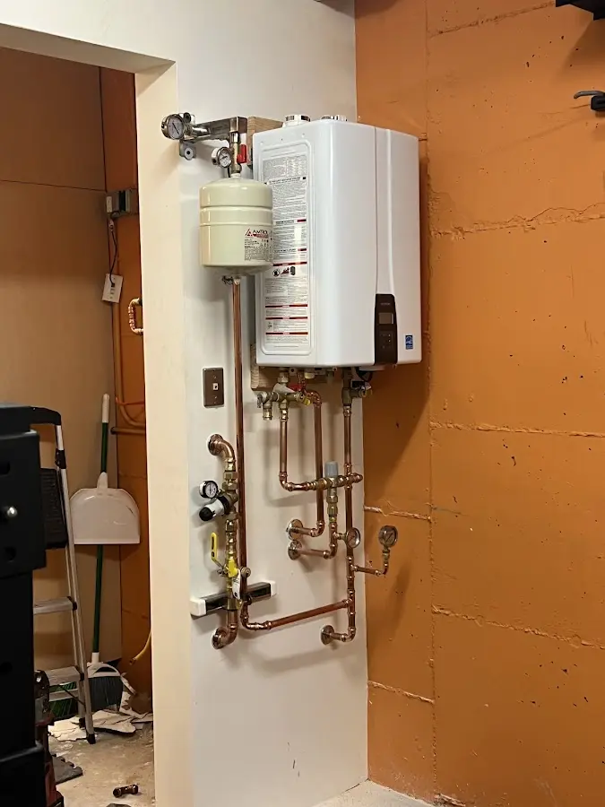 Plumbing technician inspecting water heater connections in Goldendale